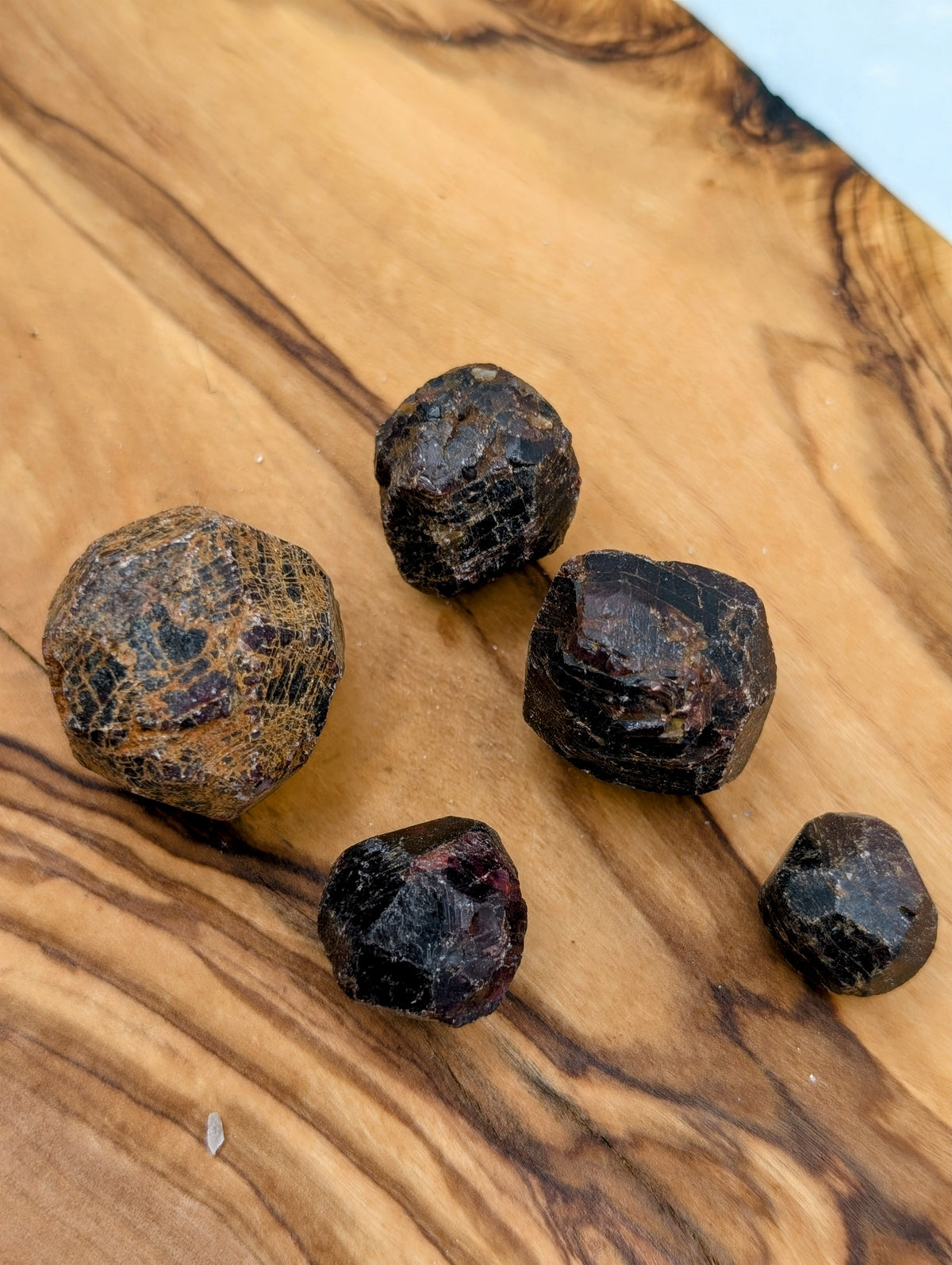 Raw Garnet crystals showing natural geometric formations and deep burgundy red coloring