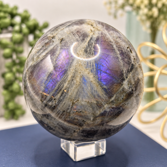 72mm Labradorite sphere showing vivid purple and blue flash with natural gray and cream patterning