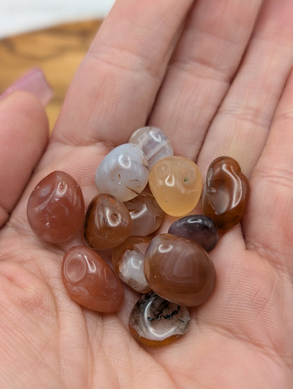 Small polished Carnelian tumble stones in orange amber cream and reddish brown tones