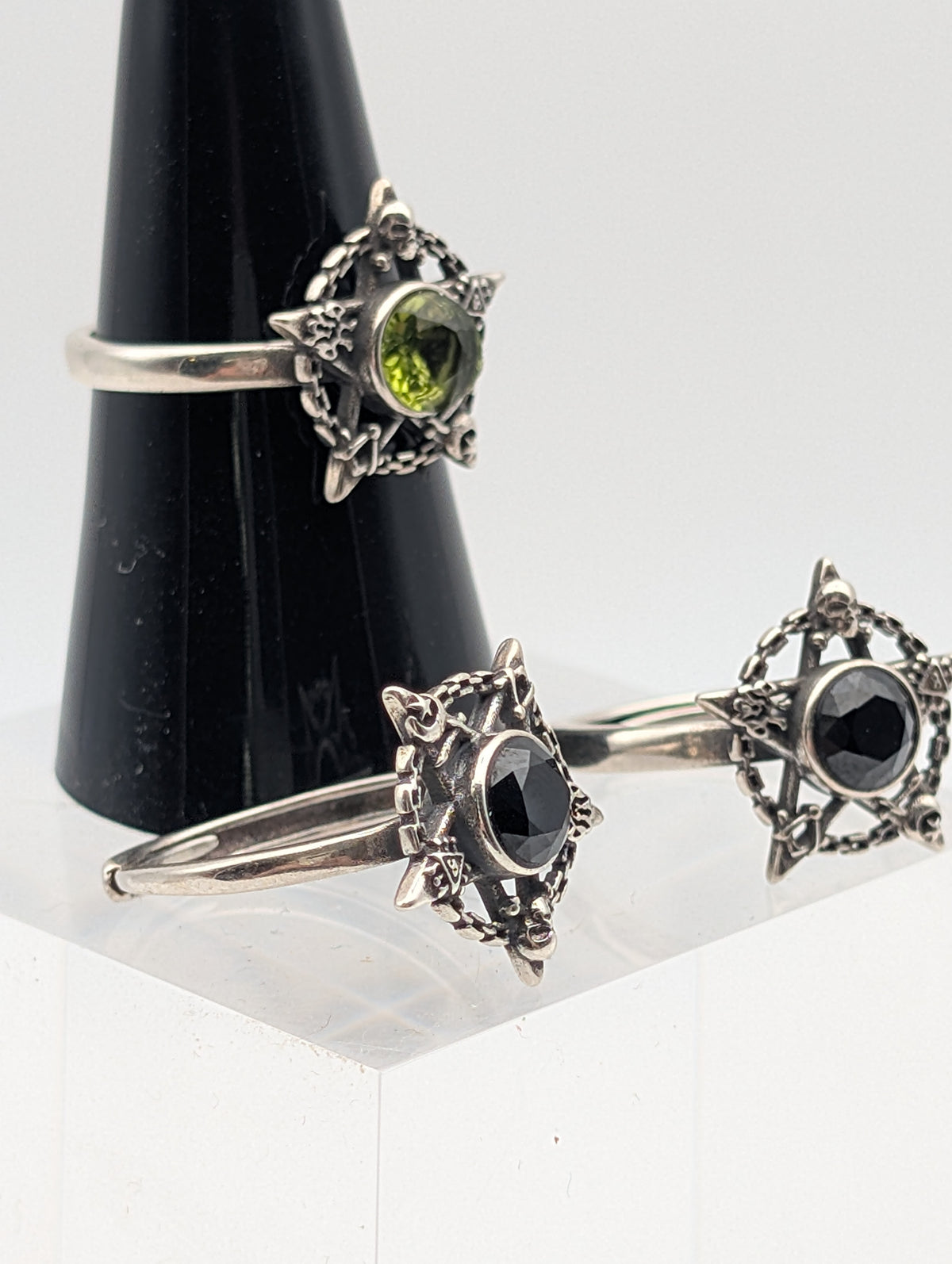 Peridot and Black Obsidian sterling silver pentagram rings showing faceted stones and ornate skull detailing
