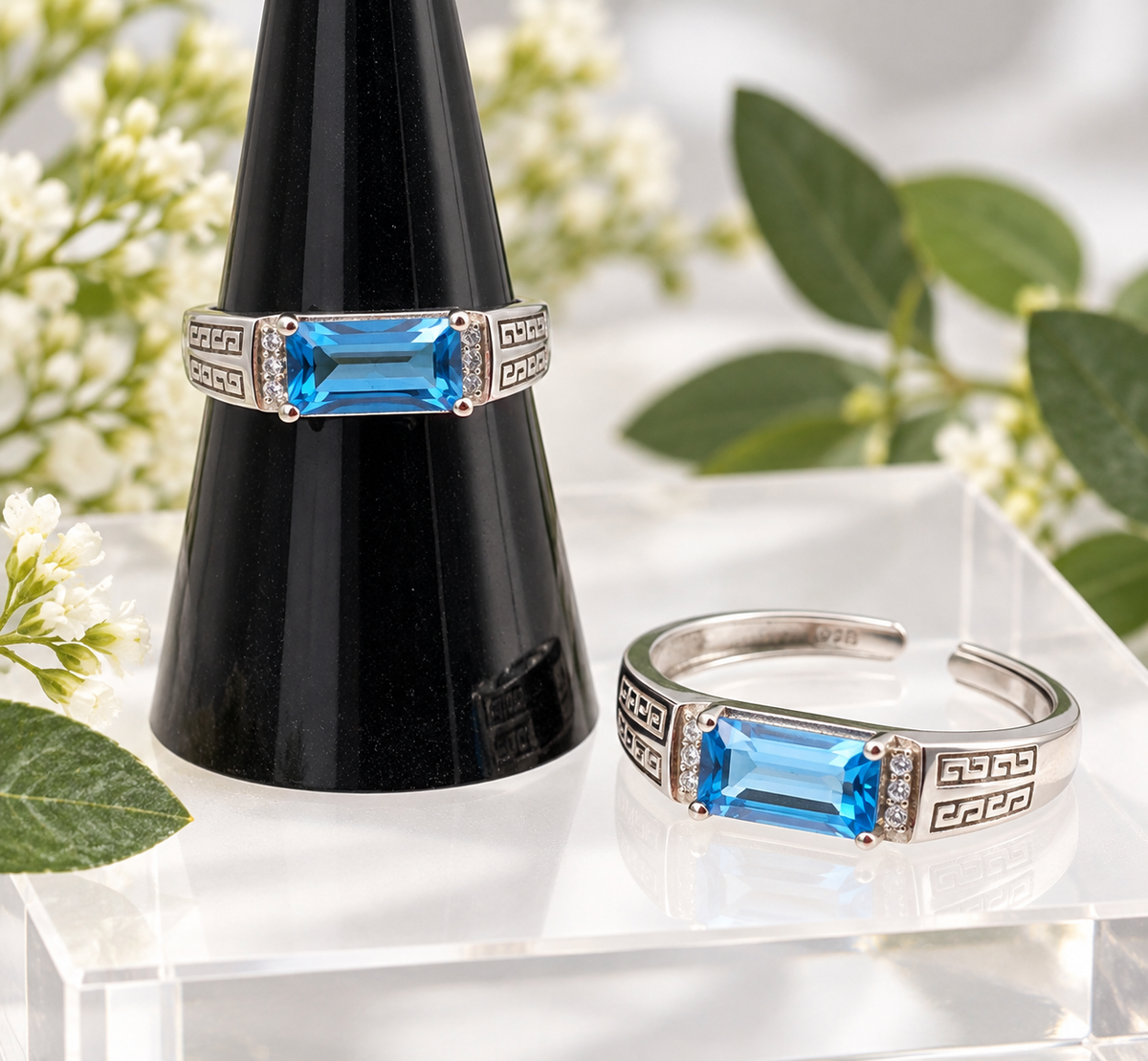 Blue Topaz sterling silver adjustable ring with rectangular blue gemstone and geometric band displayed in boutique setting