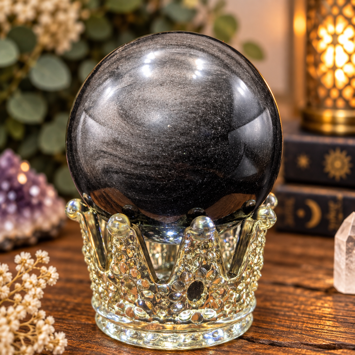 69mm Silver Sheen Obsidian sphere displaying bright silver flash on decorative glass crown stand
